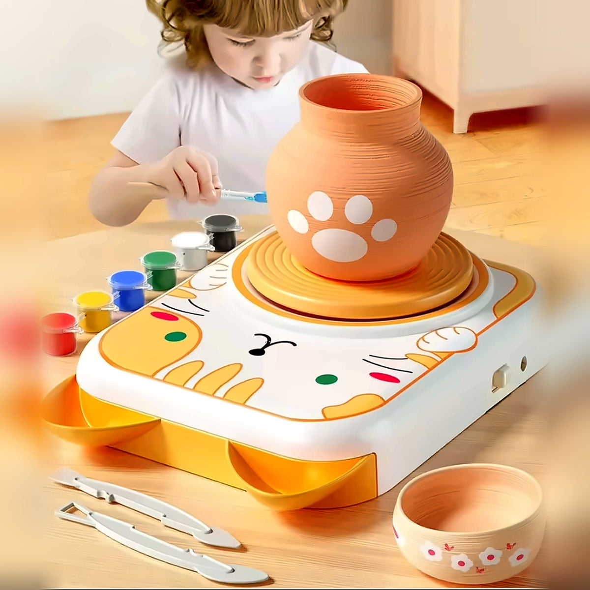 Niña pintando una pieza de cerámica hecha con el torno eléctrico Lumikids